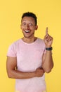 Amazed african american young man holding finger up over yellow background. Idea concept.