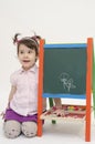 Amazed baby girl draw flowers on black board with chalk Royalty Free Stock Photo