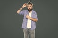 amazed bearded man with book on head on grey background