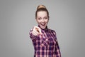 Amazed beautiful blonde girl with pink checkered shirt, collected hairstyle and makeup standing, looking at camera and with Royalty Free Stock Photo