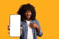 Amazed black woman showing big smartphone with blank screen Royalty Free Stock Photo