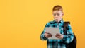 Amazed boy schooler with backpack using digital tablet Royalty Free Stock Photo