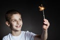 Amazed boy in white shirt holding sparkler Royalty Free Stock Photo