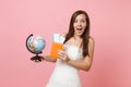 Amazed bride woman in white wedding dress holding world globe, passport boarding pass ticket, going abroad for honeymoon Royalty Free Stock Photo