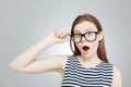 Amazed charming teenage girl in glasses with mouth opened over