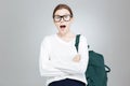 Amazed charming teenage girl in glasses standing with opened mouth