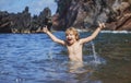 Amazed child boy playing and splashing in the sea. Kid having fun outdoors. Summer vacation and healthy family lifestyle Royalty Free Stock Photo