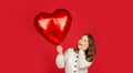 amazed child hold love heart balloon on red background. 14 february valentines day. Royalty Free Stock Photo