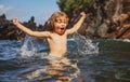 Amazed child playing and splashing in the sea. Kid having fun outdoors. Summer vacation and healthy family lifestyle Royalty Free Stock Photo