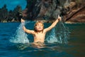 Amazed child playing and splashing in the sea. Kid having fun outdoors. Summer vacation and healthy family lifestyle Royalty Free Stock Photo