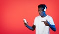 Amazed cool black guy using wireless headphones and smartphone Royalty Free Stock Photo