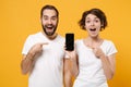 Amazed couple friends bearded guy girl in white t-shirts isolated on yellow orange background. People lifestyle concept Royalty Free Stock Photo