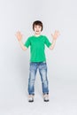 Amazed cute little boy showing his palms on white studio background