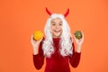 Amazed devil teenage girl with white hair hold pumpkin vegetable wear horns costume of imp on halloween party, happy Royalty Free Stock Photo