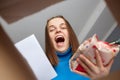 Amazed extremely happy woman looking inside box with grocery, making online shopping, holding package and consignment note in Royalty Free Stock Photo