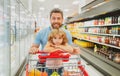 Amazed family father and child son with shopping cart buying food at grocery store or supermarket. Surprised face. Man Royalty Free Stock Photo