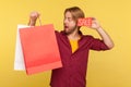 Amazed funny shopper guy holding Sale word, looking big eyes surprised expression at shopping bags Royalty Free Stock Photo