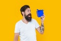 amazed guy with present isolated on yellow background. present box for guy in shirt.