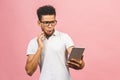 Amazed happy afro american guy holding using digital tablet looking shocked about social media news, astonished man shopper Royalty Free Stock Photo