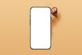 Amazed happy screaming young woman peeking out from behind big mobile empty screen for copy space and advertising area isolated