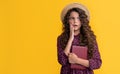 amazed kid with frizz hair hold book on yellow background