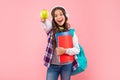 amazed kid listening music in earphones with school bag and workbook hold apple, school. Royalty Free Stock Photo