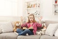 Amazed little girl with book and her favorite toys at home Royalty Free Stock Photo