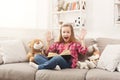 Amazed little girl with book and her favorite toys at home Royalty Free Stock Photo