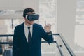 Amazed male office worker in suit being excited while trying out VR glasses