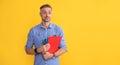 amazed mature man on yellow background with project. guy with documents in clipboard.
