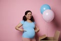 Amazed pregnant woman, expecting twins, shows two fingers looking at camera, isolated pink backdrop. Gender reveal party Royalty Free Stock Photo