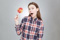 Amazed pretty teenage girl with mouth opened holding lollipop