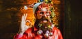 Amazed santa decorating beard. Concept of santa man with toy balls in long beard, x-mas decorations. Funny Santa with ok