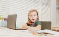 Amazed schoolboy writing at notebook in classroom at the elementary school. Little student doing test in primary school Royalty Free Stock Photo