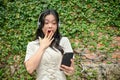 An amazed and shocked Asian woman looked at her smartphone screen with a surprised face Royalty Free Stock Photo