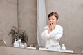 amazed surprised boy in bathrobe looking in mirror opened mouth in bathroom at home Royalty Free Stock Photo