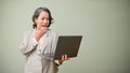 Amazed and surprised 60s aged-asian woman holding and looking at laptop screen. shocked, excited Royalty Free Stock Photo