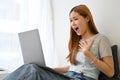 Amazed and surprised young Asian woman using laptop computer, getting an unexpected email Royalty Free Stock Photo