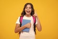 Amazed teen girl. Back to school. Schoolgirl student with school bag backpack hold book on isolated studio background Royalty Free Stock Photo