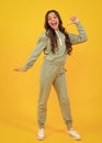 Amazed teen girl. Cute teen girl in a purple casual sports suit hoodie and pants and white sneakers posing over white Royalty Free Stock Photo