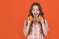 amazed teen girl hold citric fruit on orange background