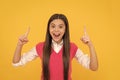 amazed teen school girl with long hair inspired with idea on yellow background, amazement