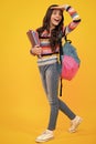 Amazed teenager. Back to school. Schoolgirl student hold book on yellow isolated studio background. School and education Royalty Free Stock Photo