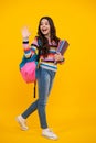 Amazed teenager. Schoolgirl, teenage student girl hold book on yellow isolated studio background. School and education Royalty Free Stock Photo