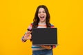 Amazed teenager. Student school girl with laptop on isolated studio background. Screen of laptop computer with copyspace