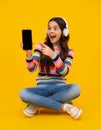 Amazed teenager. Teenage girl with smart phone. Portrait of teen child using mobile phone, cell web app. Kid showing Royalty Free Stock Photo