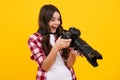 Amazed teenager. Teenager girl with dslr photo camera with zoom lens. Child photographer isoalted on yellow background Royalty Free Stock Photo