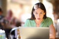 Amazed woman checking laptop content in a bar Royalty Free Stock Photo