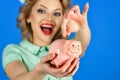 Amazed woman hold moneybox, piggy bank for savings.