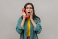 Amazed woman holding phone handset surprised by conversation open mouth shocked by unbelievable news Royalty Free Stock Photo